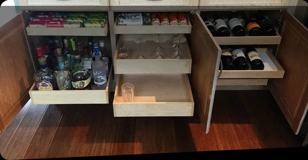 Open kitchen cabinet with black pull-out drawers.